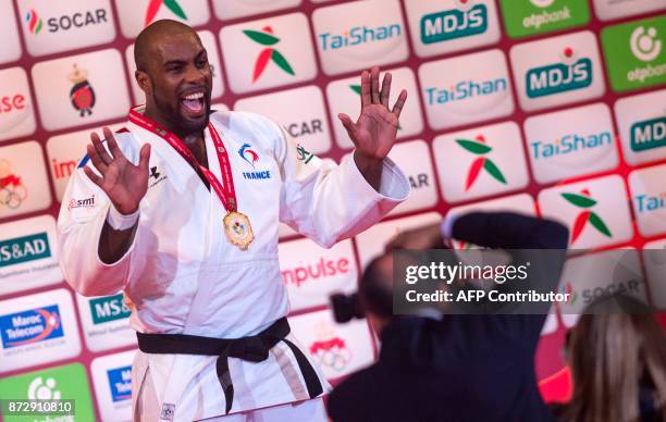 France's gold medallist Teddy Riner gestures as he celebrates on the podium after defeating Belgium's Toma Nikiforov during the Judo World...