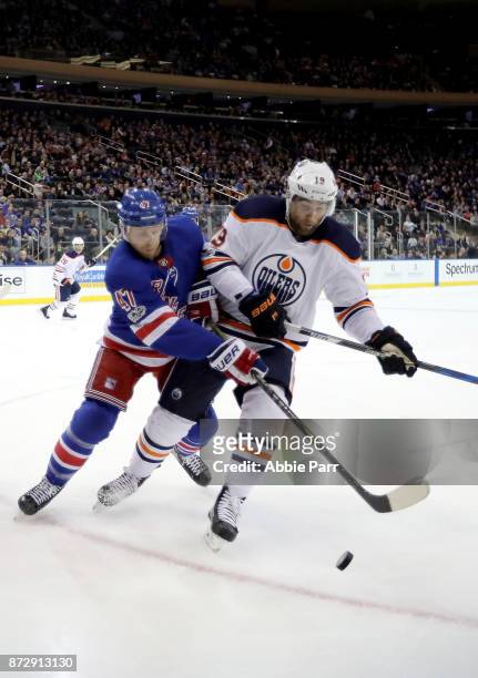 Steven Kampfer of the New York Rangers fights for the puck against Patrick Maroon of the Edmonton Oilers in the first period during their game at...