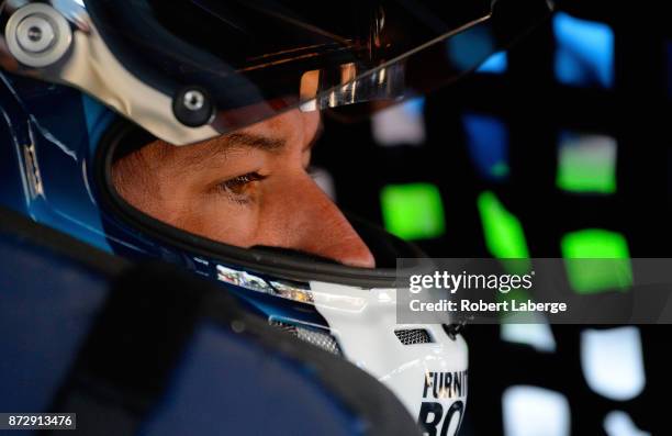 Martin Truex Jr., driver of the Auto-Owners Insurance Toyota, sits in his car during practice for the Monster Energy NASCAR Cup Series Can-Am 500 at...