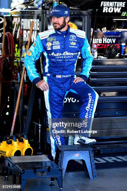 Martin Truex Jr., driver of the Auto-Owners Insurance Toyota, stands by his car during practice for the Monster Energy NASCAR Cup Series Can-Am 500...