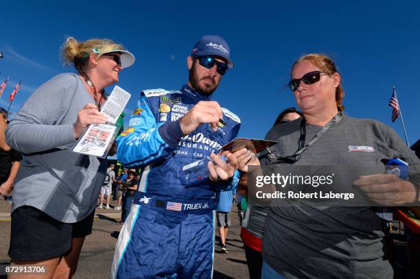 Martin Truex Jr., driver of the Auto-Owners Insurance Toyota, signs autographs during practice for the Monster Energy NASCAR Cup Series Can-Am 500 at...