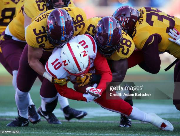 Spielman of the Nebraska Cornhuskers gets tackled by Blake Cashman and Jonathan Femi-Cole of the Minnesota Golden Gophers in the second quarter at...