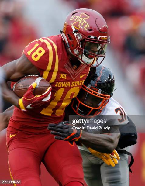 Wide receiver Hakeem Butler of the Iowa State Cyclones is tackled by safety Tre Flowers of the Oklahoma State Cowboys as he rushed for yards in the...