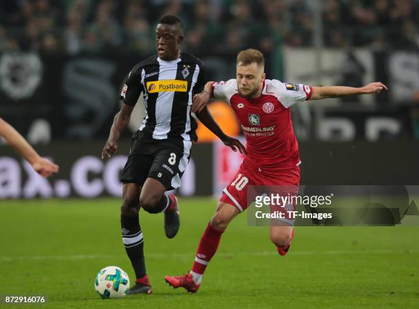 Denis Zakaria of Borussia Moenchengladbach and Alexandru Maxim of FSV Mainz 05 battle for the ball during the Bundesliga match between Borussia...