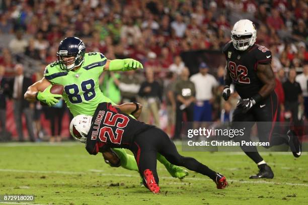 Tight end Jimmy Graham of the Seattle Seahawks is tackled by defensive back Tramon Williams of the Arizona Cardinals after a reception during the...