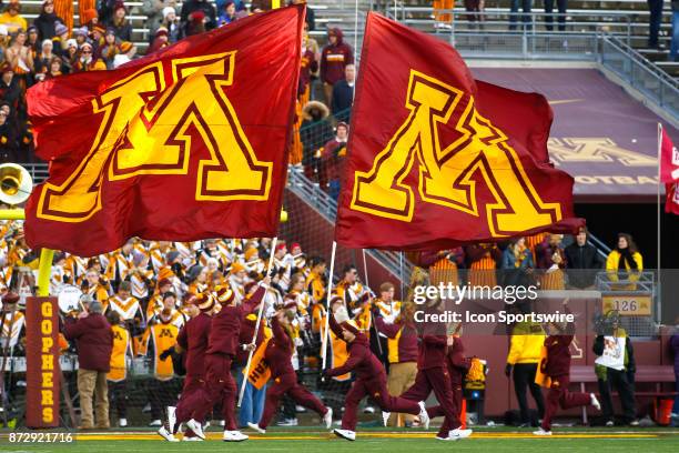 Minnesota Golden Gophers cheerleaders run with Minnesota flags during the Big Ten Conference game between the Nebraska Cornhuskers and the Minnesota...