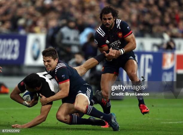 Antoine Dupont of France tackles Reiko Ioane of New Zealand during the Autumn International between France and New Zealand at the Stade de France on...