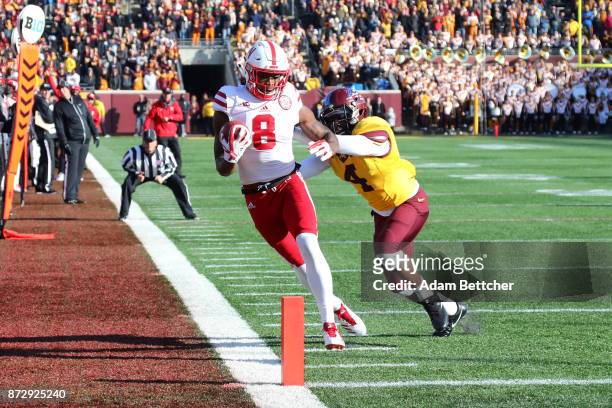 Stanley Morgan Jr. #8 of the Nebraska Cornhuskers pulls in a pass while Adekunle Ayinde of the Minnesota Golden Gophers attempts the block in the...