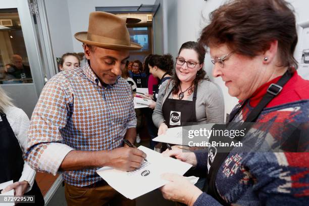 Chef Marcus Samuelsson signs a book for a student at Food Network Magazine's 2nd Annual Cooking School featuring Marcus Samuelsson on November 11,...