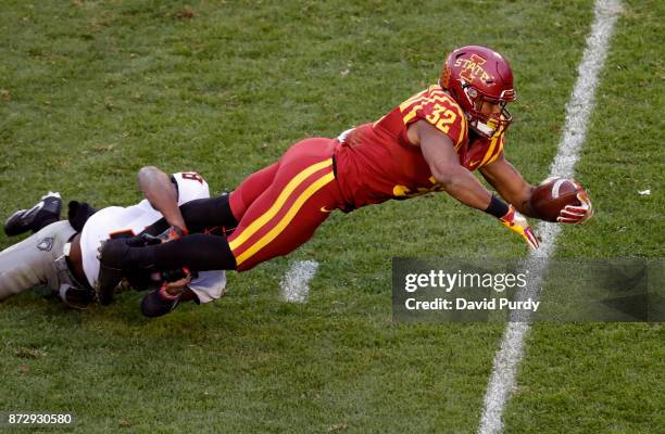 Running back David Montgomery of the Iowa State Cyclones dives into the end zone for a touchdown as cornerback Rodarius Williams of the Oklahoma...