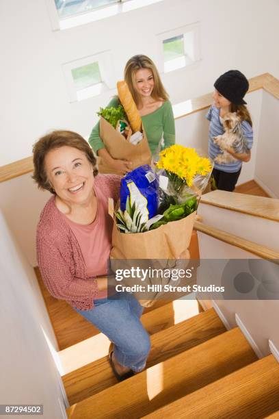 hispanic family returning home with groceries - portrait of young woman standing against steps stock pictures, royalty-free photos & images