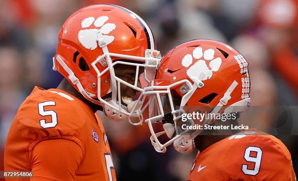 Teammates Tee Higgins and Travis Etienne of the Clemson Tigers react after a touchdown against the Florida State Seminoles during their game at...