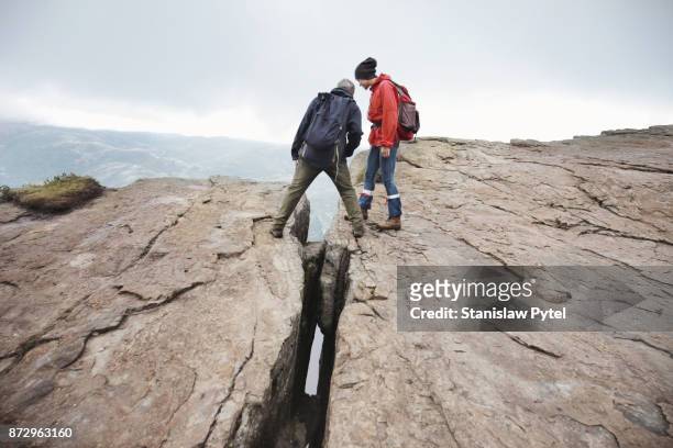 two hikers standing near ap in massive rock - cliff gap stock pictures, royalty-free photos & images