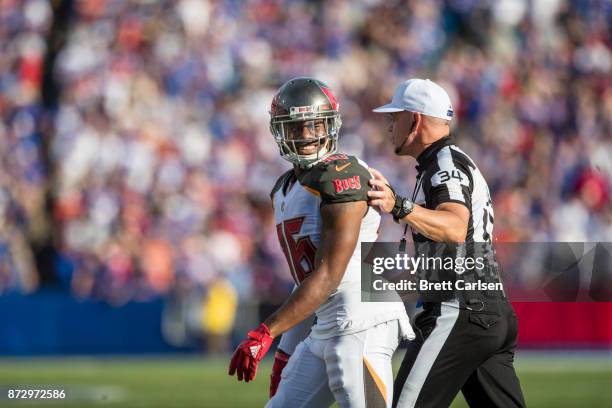 Robert McClain of the Tampa Bay Buccaneers smiles as referee Clete Blakeman escorts him across the field during the second half at New Era Field on...