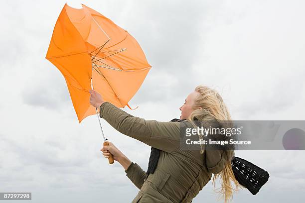 woman struggling with umbrella - broken umbrella stockfoto's en -beelden