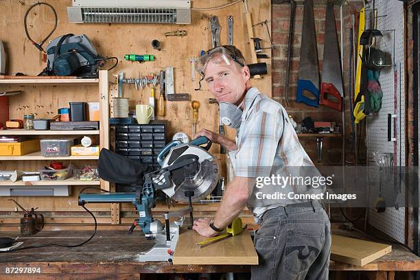A Mature Man Working With A Table Saw, Foto de stock