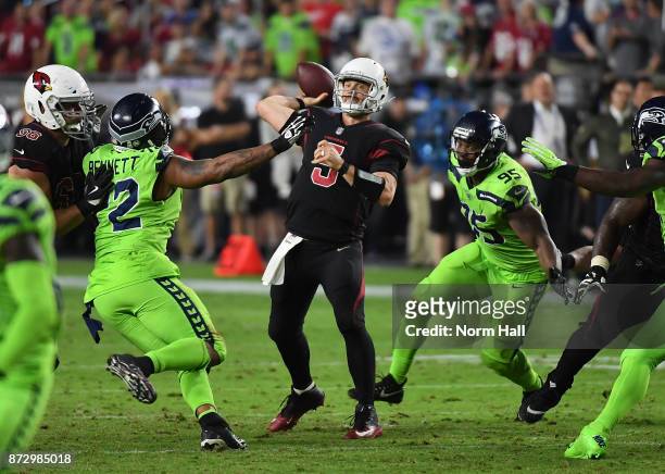 Drew Stanton of the Arizona Cardinals throws the ball while under pressure by Michael Bennett of the Seattle Seahawks at University of Phoenix...