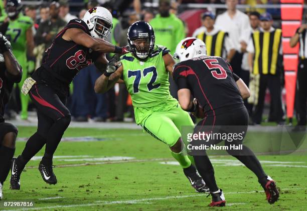 Michael Bennett of the Seattle Seahawks runs through the block of Jermaine Gresham of the Arizona Cardinals and attempts to sack Drew Stanton at...