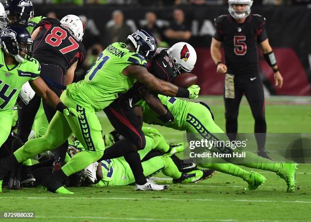 Adrian Peterson of the Arizona Cardinals looses the football while being tackled by Sheldon Richardson of the Seattle Seahawks at University of...