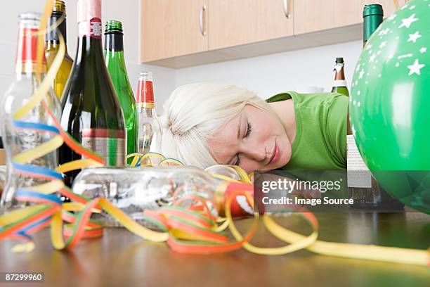 woman sleeping after a party - messy table after party stock-fotos und bilder