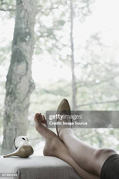 a businesswoman resting her feet - businesswoman barefoot stock-fotos und bilder