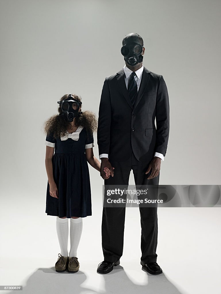 Father and daughter in gas masks