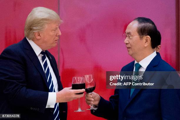 Vietnamese President Tran Dai Quang toasts US President Donald Trump during a state dinner in Hanoi on November 11, 2017. Trump arrived in the...