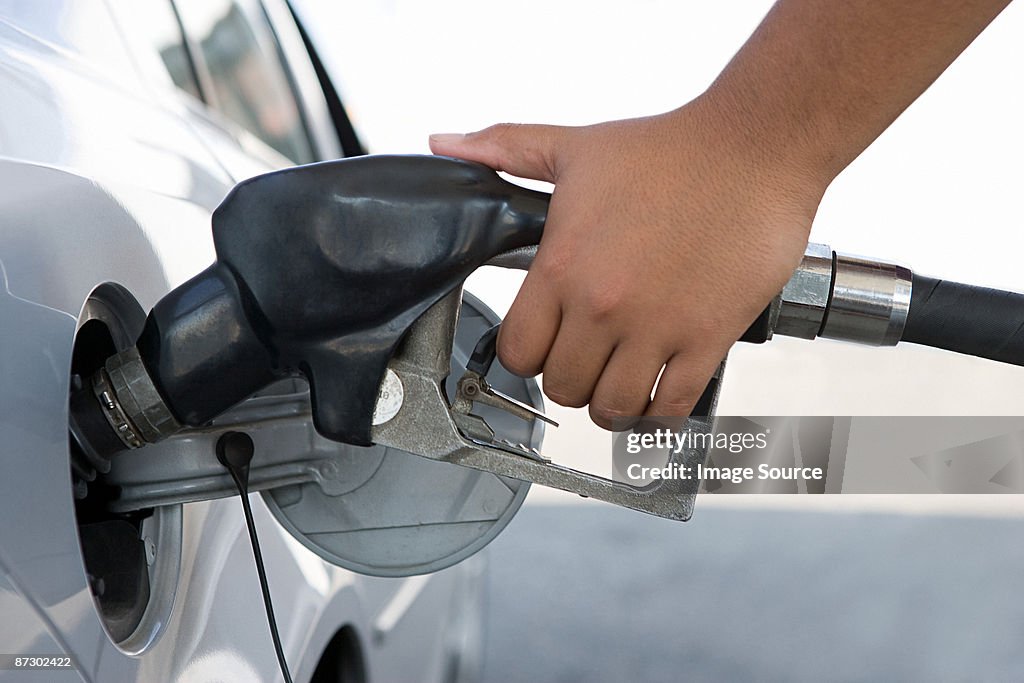 A person filling a petrol tank