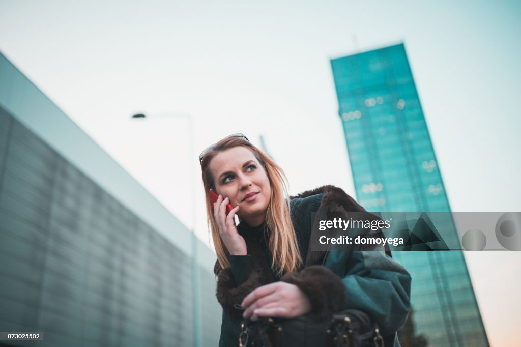 Young woman using phone in the city street