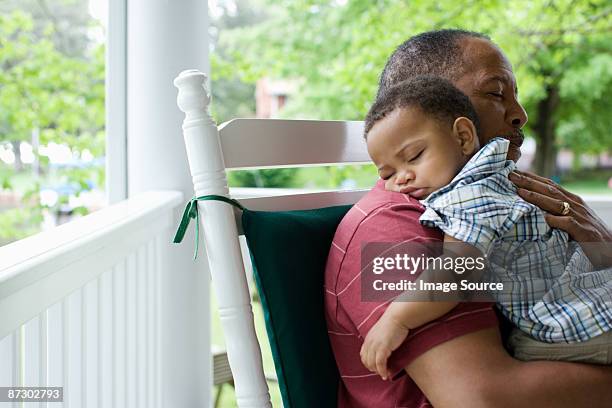 a grandfather holding his sleeping grandson - cute baby sleeping stock pictures, royalty-free photos & images