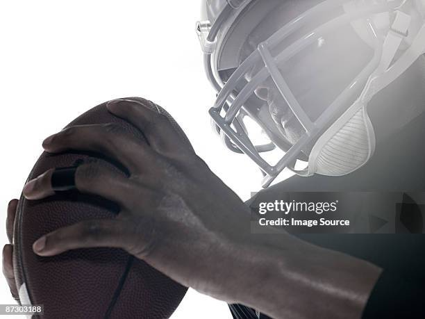 an american football player holding a football - profundo jugador de fútbol americano fotografías e imágenes de stock