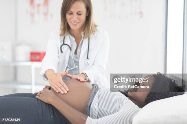 懷孕的婦女在檢查與她的女醫生 - obstetrician 個照片及圖片檔