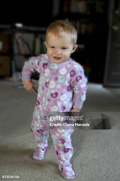 hey cute baby in purple pajamas is taking her first steps. - hey baby stock pictures, royalty-free photos & images
