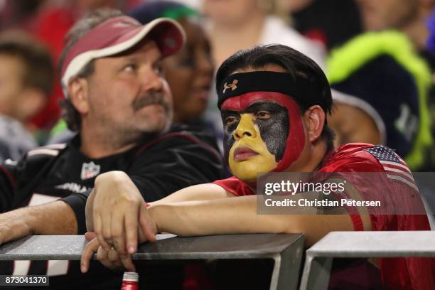 Arizona Cardinals fans react during the first half of the NFL game against the Seattle Seahawks at the University of Phoenix Stadium on November 9,...