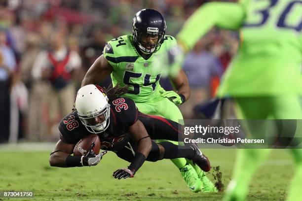 Running back Andre Ellington of the Arizona Cardinals dives with the football past middle linebacker Bobby Wagner of the Seattle Seahawks during the...