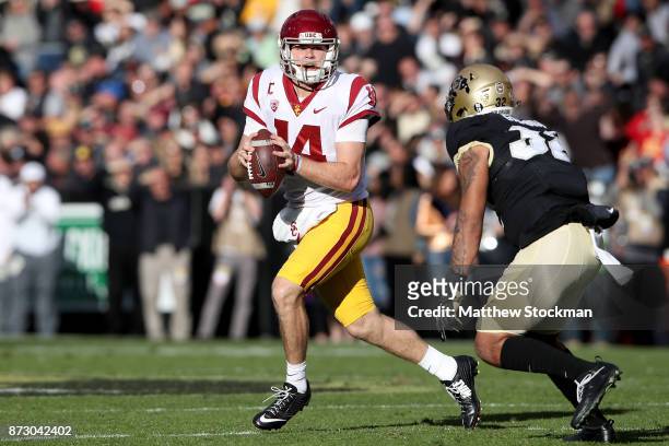 Quarterback Sam Darnold of the USC Trojans is chased out of the pocket by Rick Gamboa of the Colorado Buffaloes at Folsom Field on November 11, 2017...