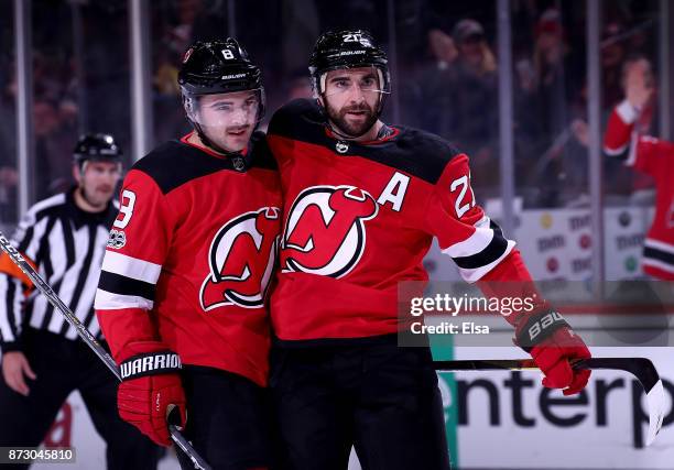 Will Butcher of the New Jersey Devils congratulates teammate Kyle Palmieri after he scored in the second period against the Florida Panthers on...