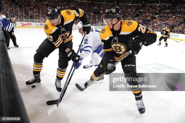 Kevan Miller and Riley Nash of the Boston Bruins fights for the puck against Patrick Marleau of the Toronto Maple Leafs at the TD Garden on November...