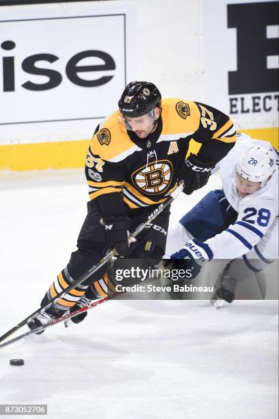 Patrice Bergeron of the Boston Bruins skates with the puck against Connor Brown of the Toronto Maple Leafs at the TD Garden on November 11, 2017 in...
