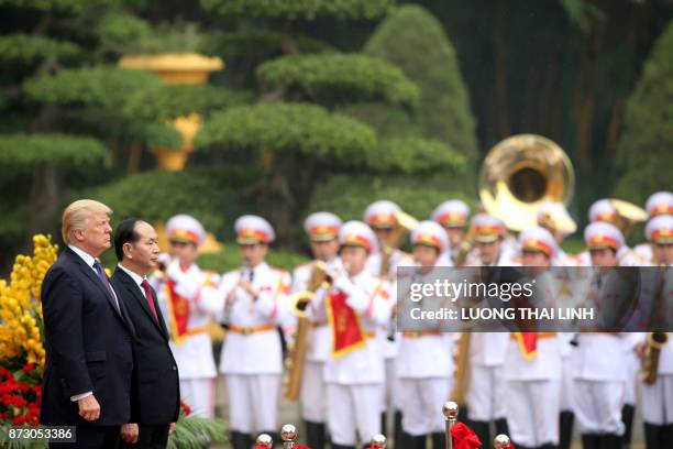 President Donald Trump, accompanied by his Vietnamese counterpart Tran Dai Quang, observe national anthems during a welcoming ceremony at the...