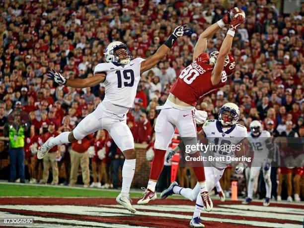 Tight end Grant Calcaterra of the Oklahoma Sooners catches a touchdown pass as linebacker Montrel Wilson of the TCU Horned Frogs defends at Gaylord...