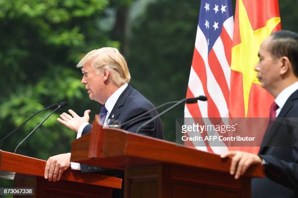 President Donald Trump attends a joint press conference with his Vietnamese counterpart Tran Dai Quang at the Presidential Palace in Hanoi on...