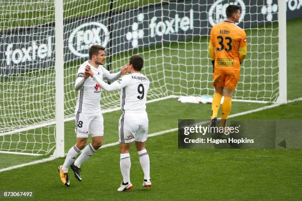 Dario Vidosic of the Phoenix celebrates with teammate Andrija Kaludjerovic after scoring a goal while Liam Reddy of the Glory looks on in...