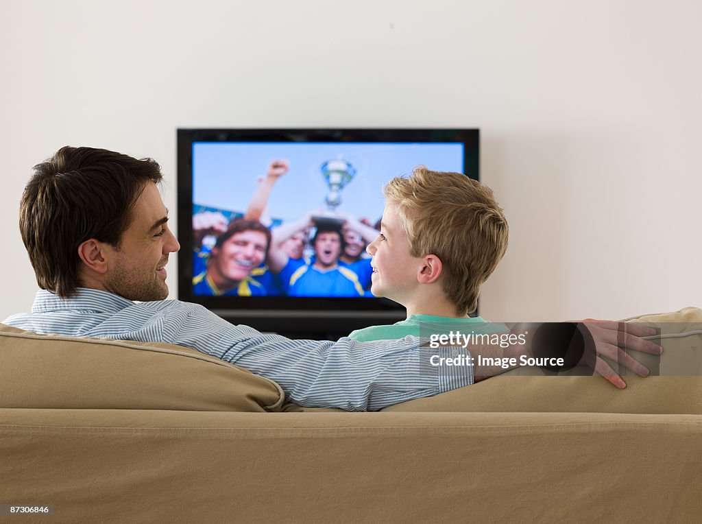 Father and son watching a football match