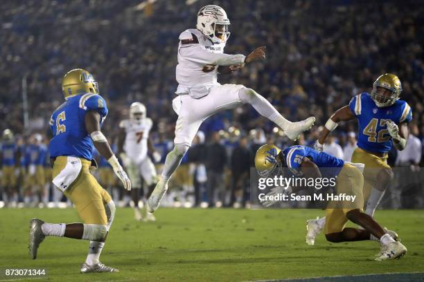 Manny Wilkins of the Arizona State Sun Devils leaps past Adarius Pickett, Jamel Cook and Kenny Young of the UCLA Bruins for a touchdown during the...