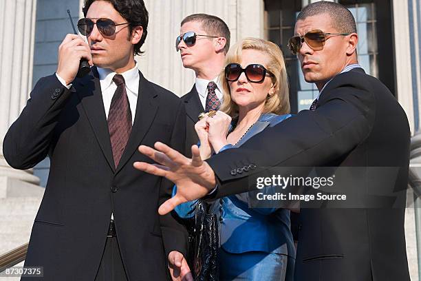 body guards protecting a woman - lijfwacht stockfoto's en -beelden