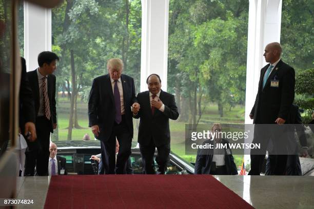 President Donald Trump walks with Vietnamese Prime Minister Nguyen Xuan Phuc in Hanoi on November 12, 2017. Trump arrived in the Vietnamese capital...