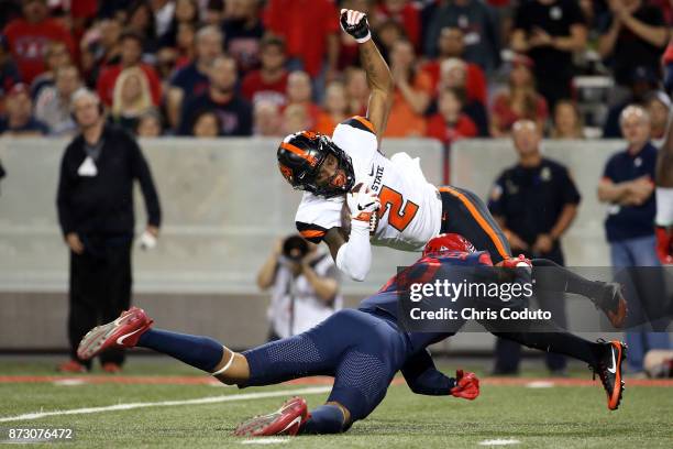 Cornerback Shawn Wilson of the Oregon State Beavers is tackled by wide receiver Shawn Poindexter of the Arizona Wildcats after intercepting a pass...