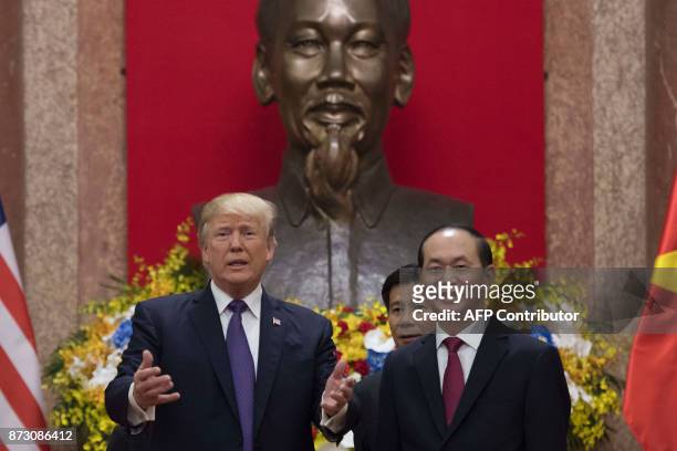 Vietnamese President Tran Dai Quang and US President Donald Trump talk during a bilateral meeting in Hanoi on November 12, 2017. Trump arrived in the...