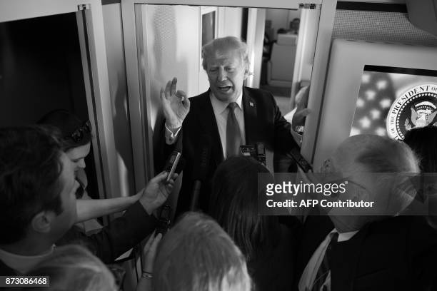 President Donald Trump speaks to reporters after departing the Asian Pacific Economic Cooperation forum in Danang on November 11, 2017. / AFP PHOTO /...